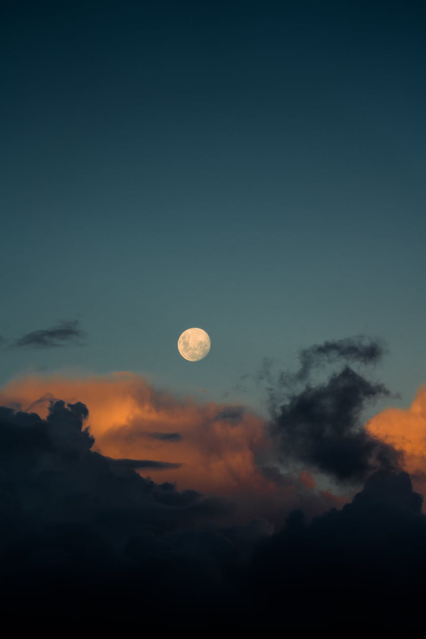 moon among fluffy clouds on a dusky evening